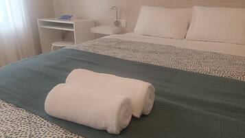 Una habitación de hotel con una cama, un escritorio y una silla.
