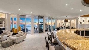 Eine moderne Lobby mit einer gebogenen Bar, Sitzbereichen und großen Fenstern mit Blick auf das Meer.