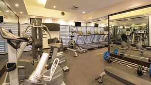 A modern gym with various cardio machines, weightlifting equipment, and a large mirror reflecting the space. - Protea Hotel by Marriott Dar es Salaam Oyster Bay (Dar es Salaam)