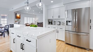 A modern kitchen with white cabinetry, stainless steel appliances, and pendant lighting. - Desert Sol l Heated Pool l Hot Tub l Putting Green (Scottsdale)
