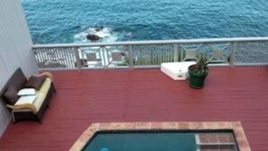 A pool area with a hot tub, a lounge chair, and a potted plant. - Ocean views from every room! (St Thomas)