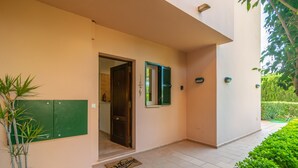 Une entrée propre et moderne, avec une porte, un paillasson et une plante en pot.