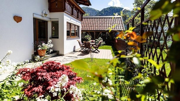 Une maison avec un patio, une clôture en bois et une vue sur la montagne.