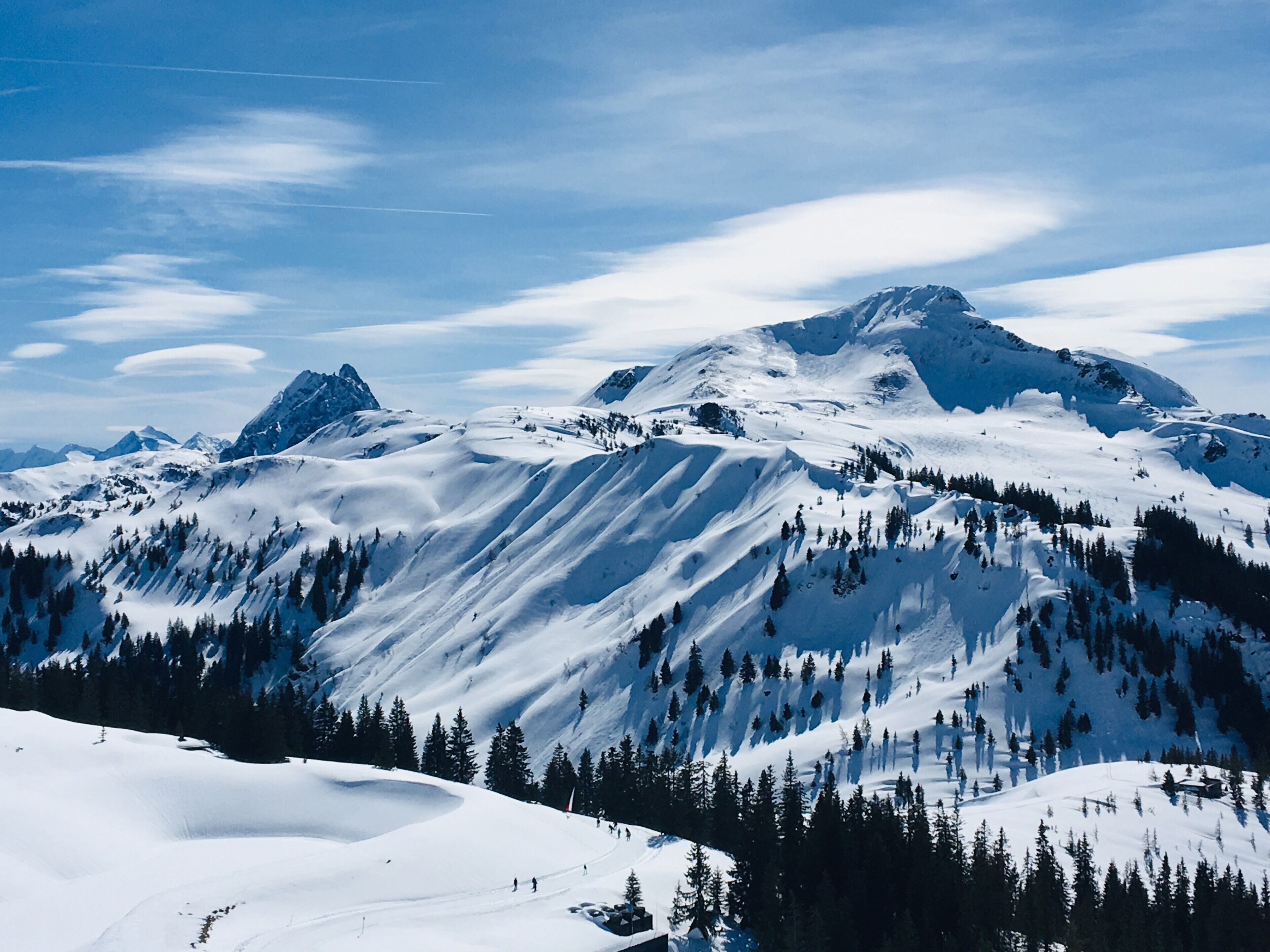 Un paysage de montagne enneigé, sous un ciel dégagé.
