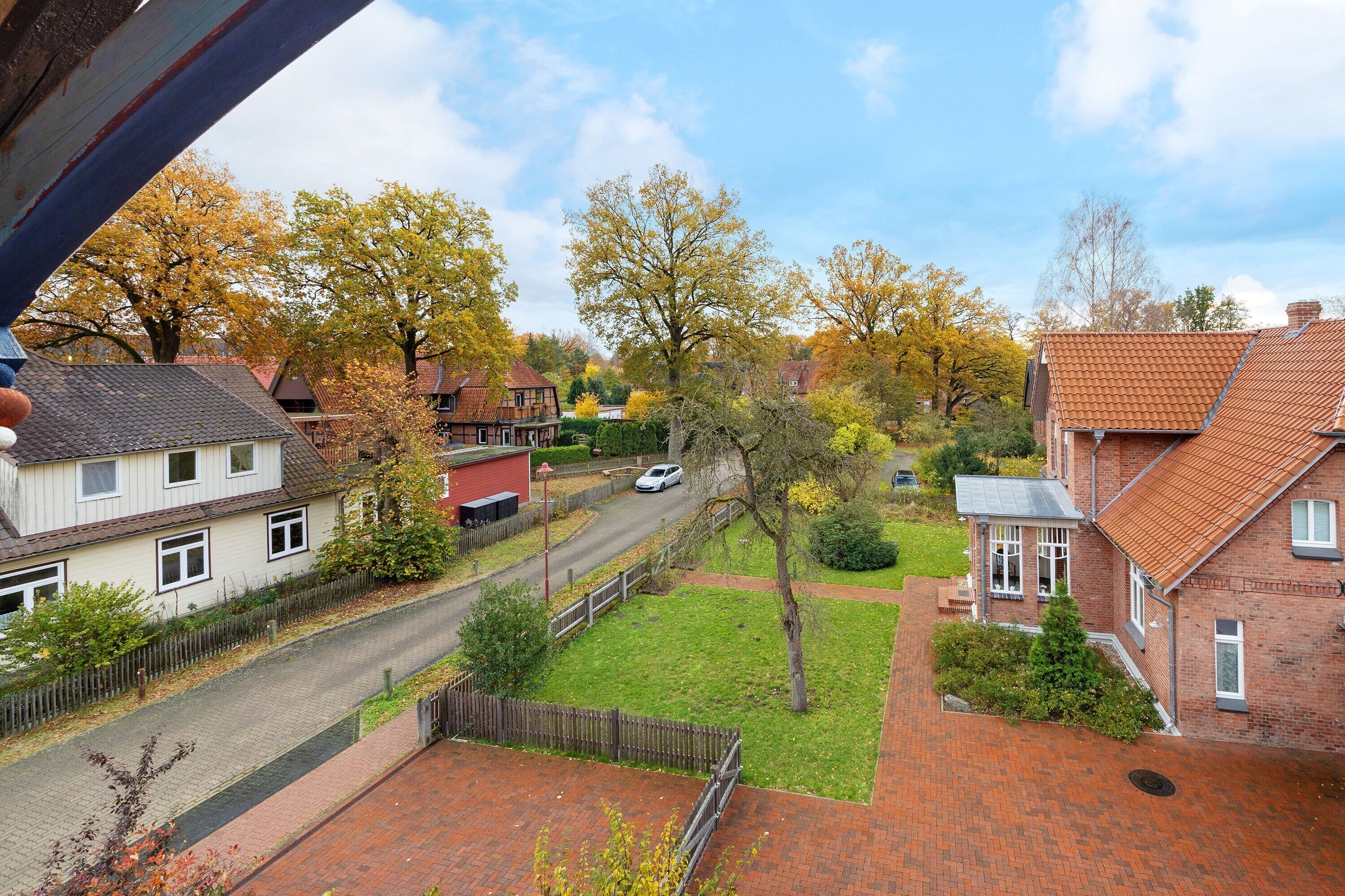 En boligvej med huse, klar himmel og efterårsfarver.