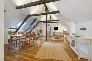 A loft-style room with a dining area, a sofa, a TV, and a chalkboard. - Apartment 'Örtzetal' with Wi-Fi (Hermannsburg)