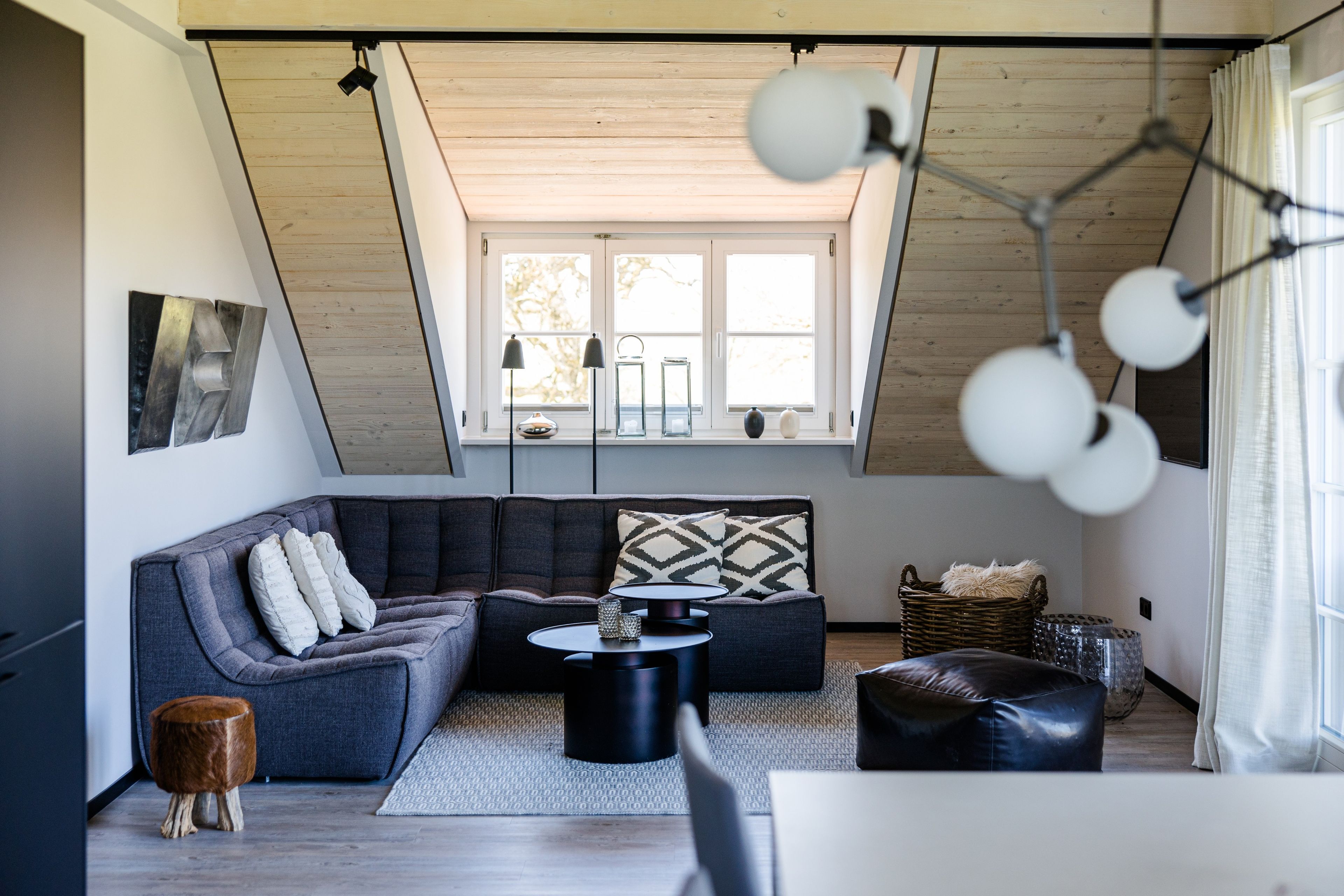 Una sala de estar moderna con un sofá modular, una mesa de centro y un ventanal con luz natural.