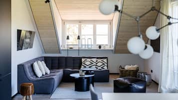 Una sala de estar moderna con un sofá modular, una mesa de centro y un ventanal con luz natural.