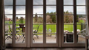 A view through a glass door to an outdoor deck with chairs and tables. - Appartement with Balcony and Wi-Fi (Wangen im Allgäu)