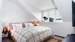 A bedroom with a bed, bedside table, lamp, and window. - Appartement with Balcony and Wi-Fi (Wangen im Allgäu)