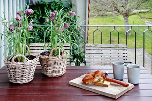 Wicker baskets with plants, a wooden cutting board with food, and two gray cups on a wooden table. - Appartement with Balcony and Wi-Fi (Wangen im Allgäu)