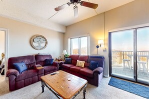 A living room with a red leather sofa, a wooden coffee table, and a ceiling fan.