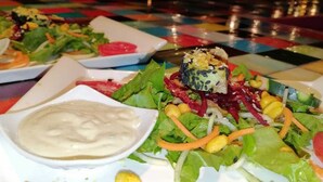 Een tafel met een kleurrijke tafelkleed en een salade met blauwkaas.
