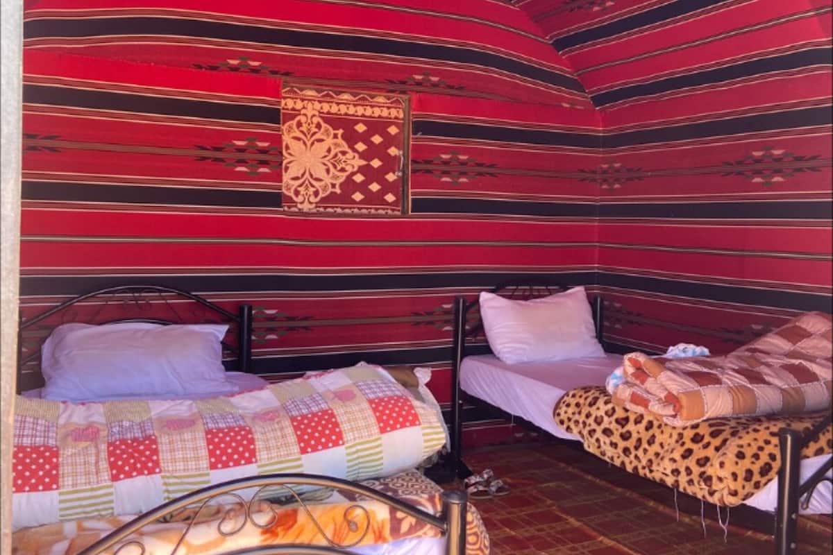 A room with two beds, each with a different patterned bedspread.