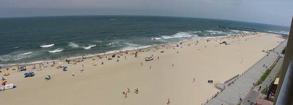 Enjoy a serene beach experience with gentle waves and a scenic promenade.
