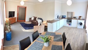 A compact living space with a dining area, kitchenette, and a sofa in the living room. - ⭐BROOKS⭐BFast,WiFi,Nflx⭐UberEats, Walk2Shop, (Norlane)