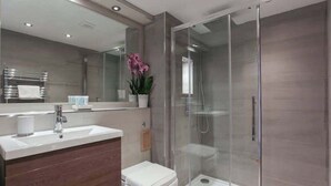 A modern bathroom with a glass-enclosed shower, a white sink, and a large mirror. - LN Collection - Grassmarket (Edinburgh)