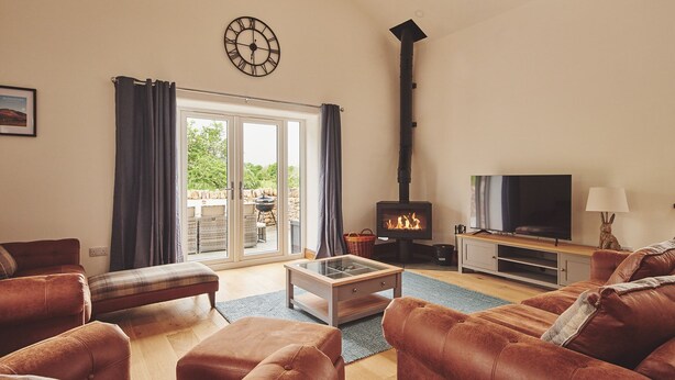 A living room with a fireplace, a television, and comfortable seating. - Plum Cottage -  Luxury Cottages (Appleby)