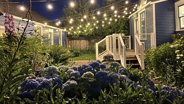 A house with a wooden deck and string lights. - Amazing Victorian 4BR w/Hot Tub 5 Min to Downtown (Bellingham)