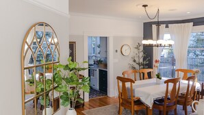 A dining area with a wooden table and chairs, a black console table with a mirror, and a potted plant. - Amazing Victorian 4BR w/Hot Tub 5 Min to Downtown (Bellingham)