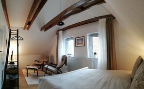 A bedroom with a bed, two chairs, a coat rack, and a radiator. - Gemütliche, Frisch Renovierte Wohnung Direkt am Elsflether Weserdeich (Elsfleth)