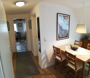 A dining area with a wooden table and chairs, a framed picture on the wall, and a lamp. - Gemütliche, Frisch Renovierte Wohnung Direkt am Elsflether Weserdeich (Elsfleth)