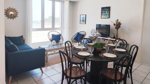 Un espace repas comprenant une table ronde, des chaises et un téléviseur.