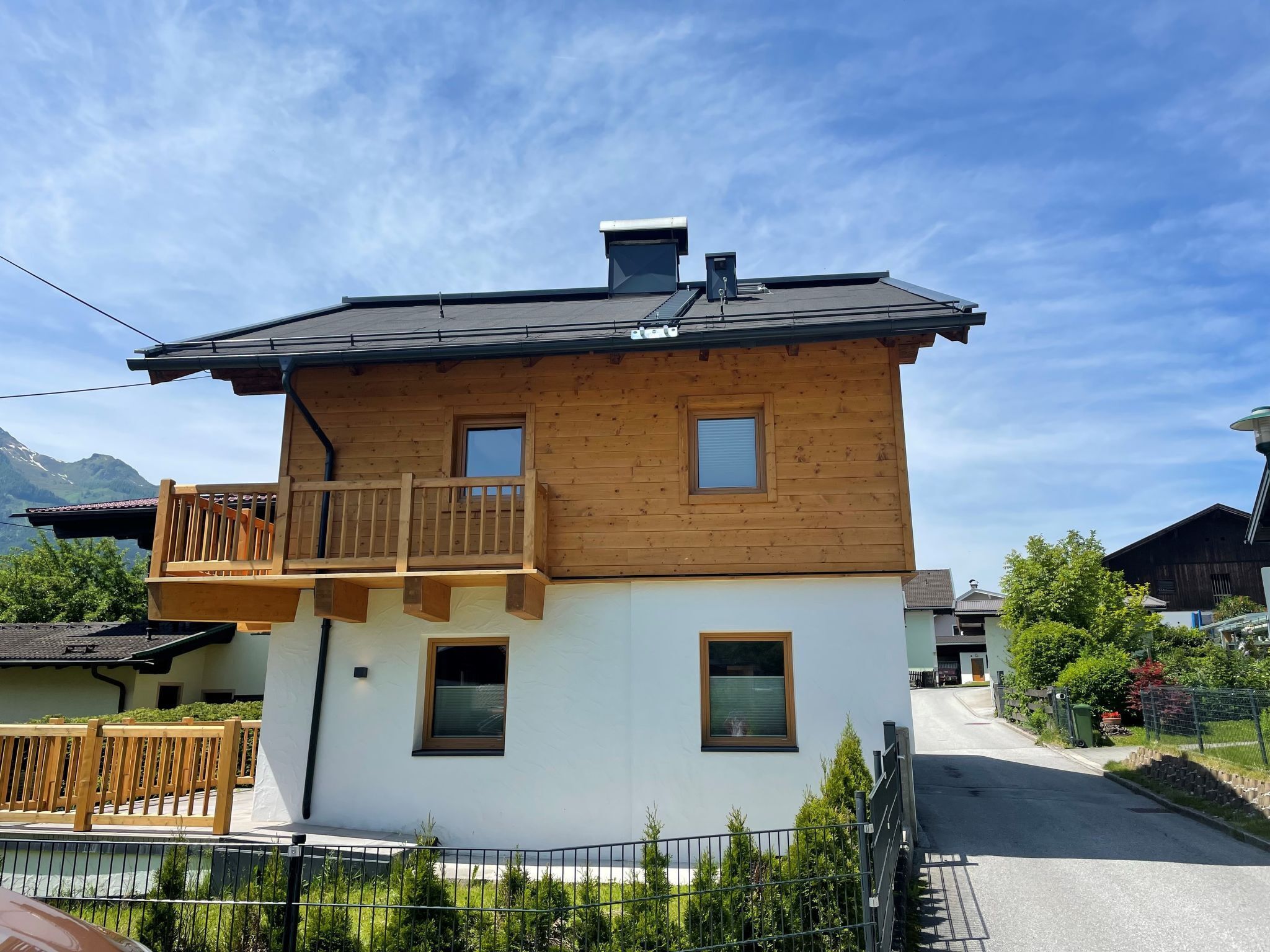Une maison en bois à deux étages, dotée d’un balcon, d’une cheminée et d’une petite fenêtre à l’étage supérieur.