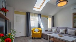 A modern living room with a yellow armchair, a grey sofa, and a white coffee table. - Vacation home Veli by Interhome (Opatija/Veli Brgud)
