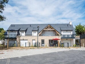 A modern two-story building with a flat roof, large windows, and a covered outdoor seating area. - Les Villas du Men Du by Interhome (Carnac)