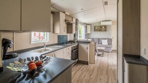Una cocina moderna con una isla central, un área de comedor con sofá y vistas al exterior.