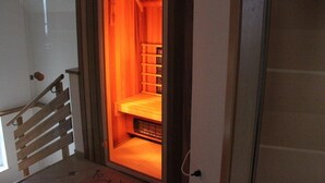 Et sauna-rum med træbænk og hylder.