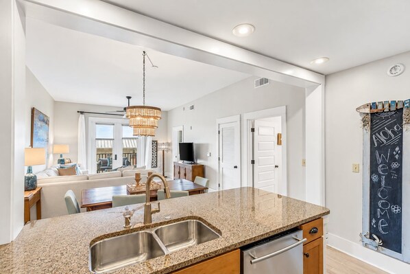 A modern kitchen with granite countertops, stainless steel sinks, and a dishwasher.