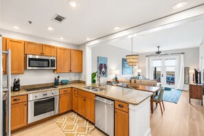 A modern kitchen with wooden cabinets, stainless steel appliances, and a central island.