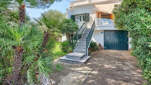 A two-story building with a staircase leading to a balcony. - Cas Predi by Rentallorca (Can Picafort)