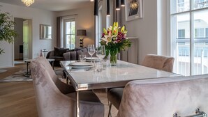 A modern dining area with a marble table, elegant chairs, and a vase of flowers. - Obergeschosswohnung Panorama-residenz 26 (Ostseebad Wustrow)