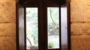 Une cuisine rustique avec un évier en bois, deux fenêtres et une vue sur la verdure environnante.