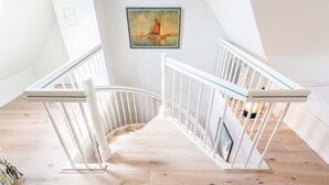 A staircase with white railings and a wooden floor.