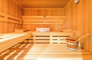 A wooden sauna with benches and a bucket. - Gemütliches Hausteil in Ruhiger Wohnlage mit Nähe zum Dorfteich in Wenningstedt (Wenningstedt-Braderup (Sylt))