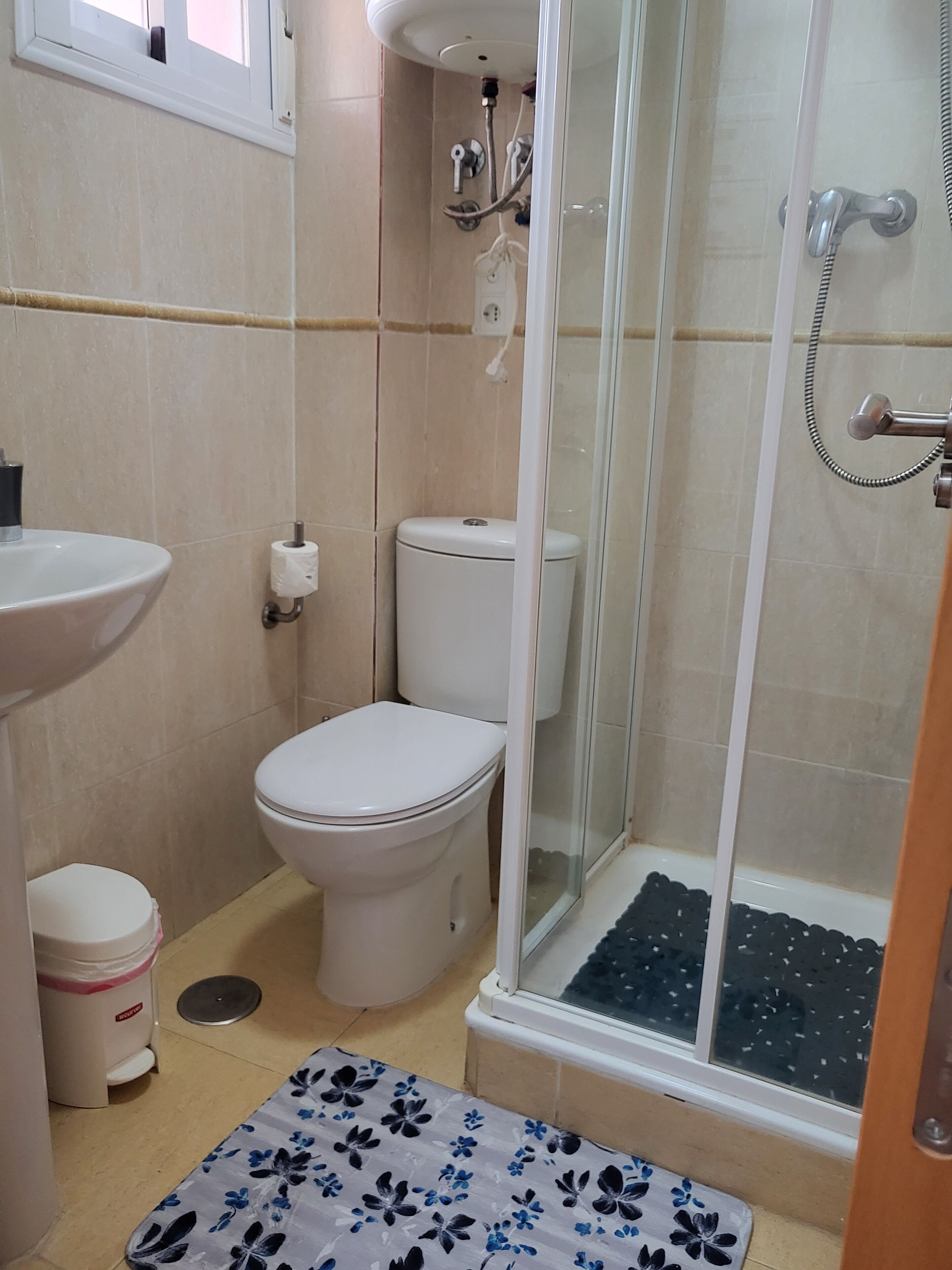 Une salle de bain avec des toilettes, un lavabo et une douche.