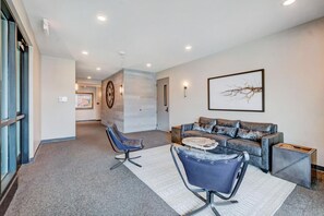 A modern living room with a sofa, two chairs, a coffee table, and a large abstract painting on the wall. - Downtown WP Loft 206 I Huge Hot Tub I Great Views I Bunk Room I Discounted Attractions (Winter Park)