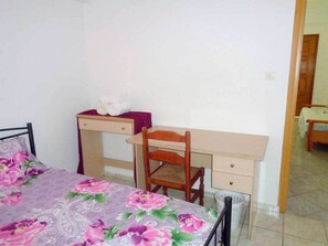 Un dormitorio con una cama, un escritorio y una silla.