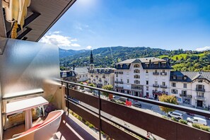 Un balcon donnant sur la ville, les bâtiments et le clocher d’une église.