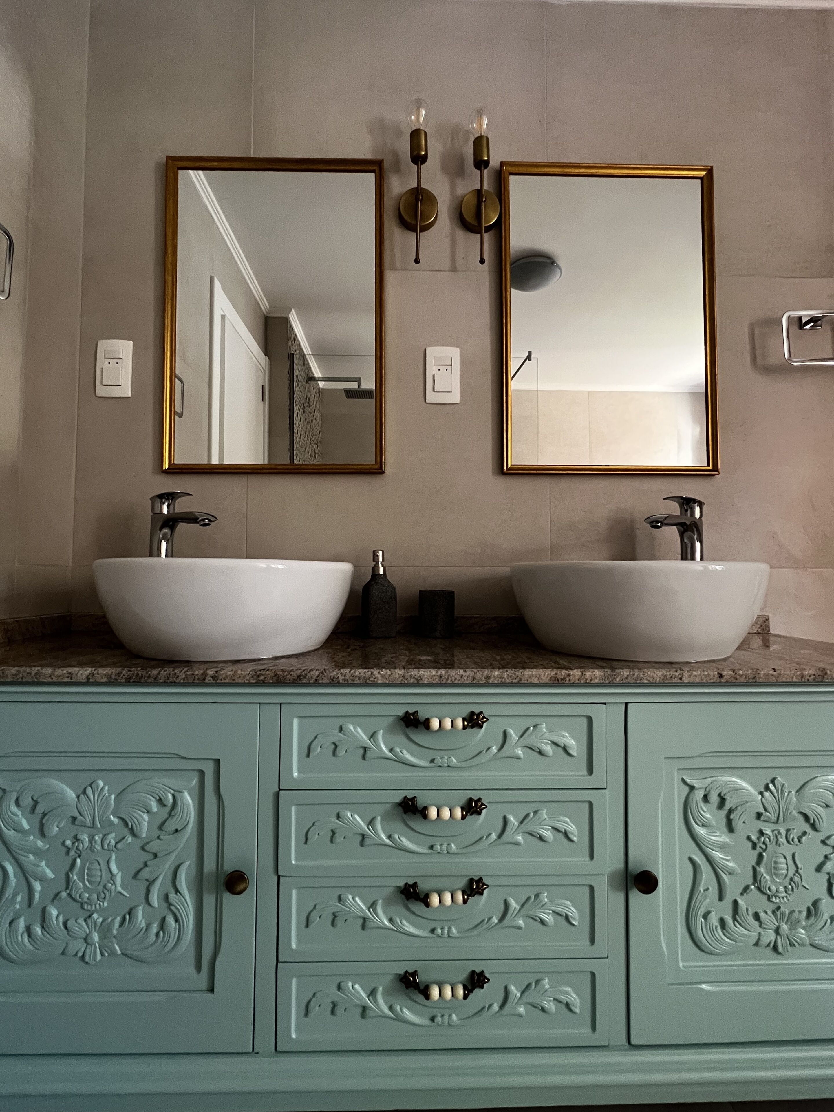 A bathroom with two sinks, a mirror, and a cabinet with drawers.