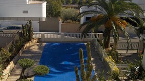 Ett bostadsområde med en swimmingpool, palmer och hus.