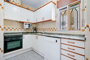A kitchen with white cabinets, a microwave, a stove, and a dishwasher.