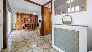 Een kamer met betegelde vloer, houten meubels, een spiegel en een radiator.
