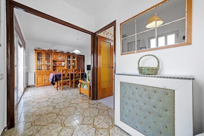 A room with a tiled floor, wooden furniture, a mirror, and a radiator.