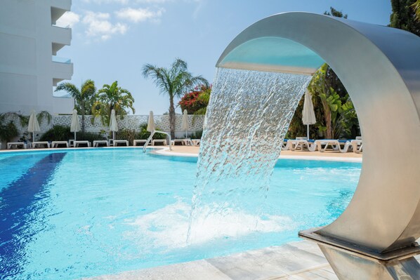 Una piscina techada, una piscina al aire libre de temporada, sombrillas