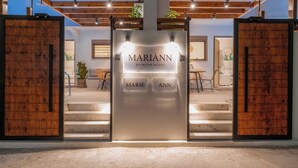 Ein Hotel Eingang mit einer Namensschild, auf der 'MARIANN premium suites' steht, einer Treppe und Holztüren.